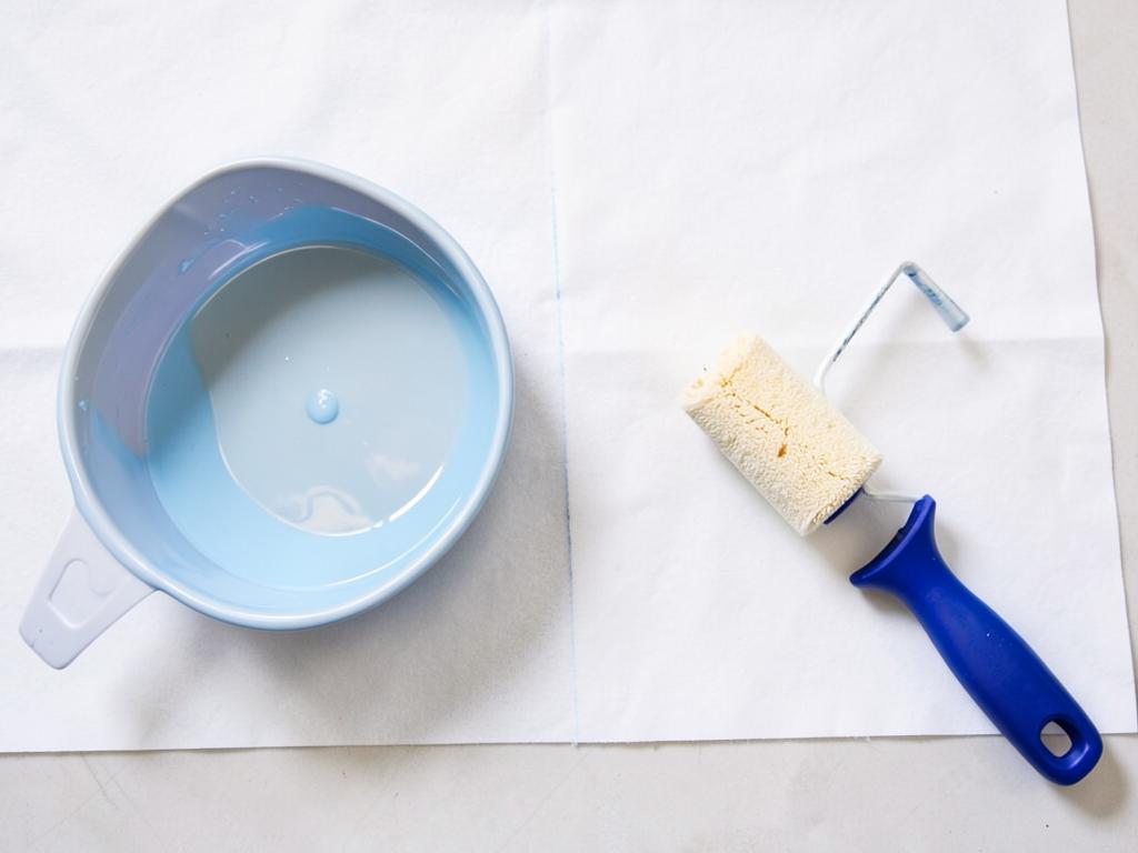 Paint tray and roller on a drop sheet